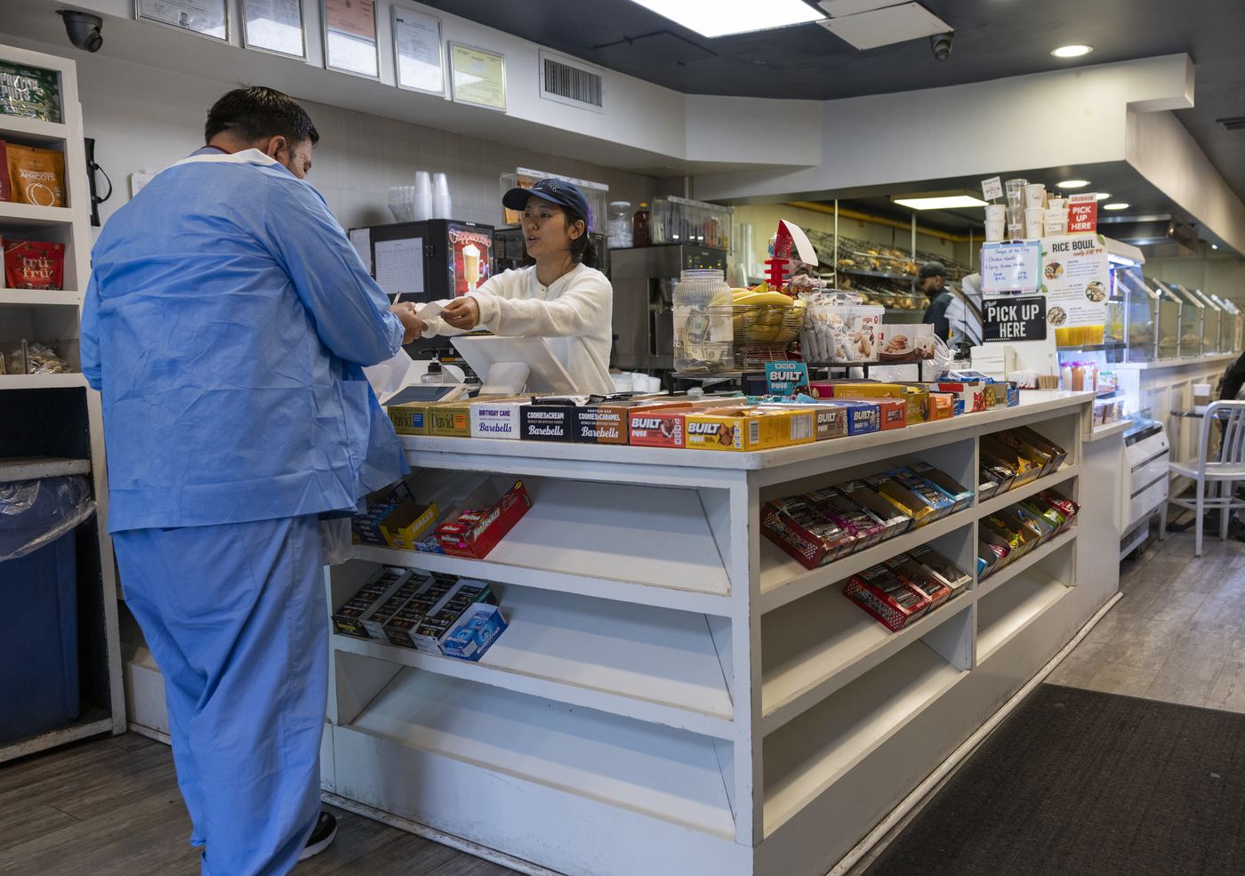A cashier hands a customer their receipt at a retail counter